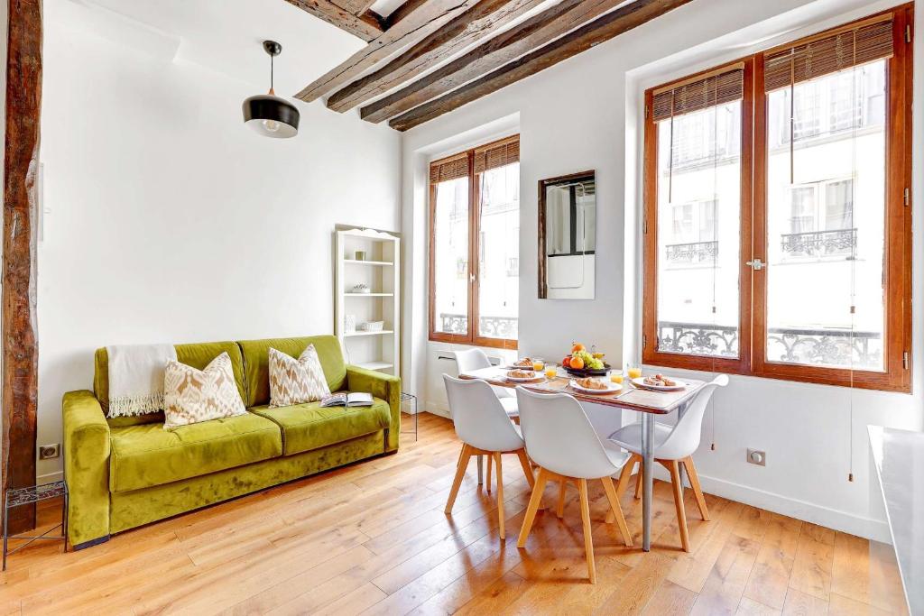 パリにあるLe Marais - Pont Marie - Paris Vacation Rentalsの緑のソファとテーブルのあるリビングルーム