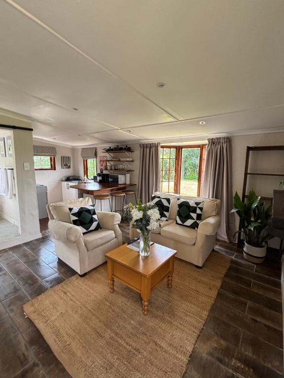 a living room with two couches and a coffee table at Devonshire Cottage in Nottingham Road