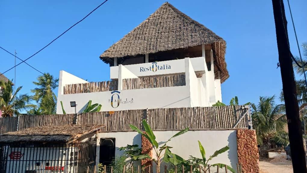 南威Ô TALIA Hôtel and SPA的顶部有标志的建筑物