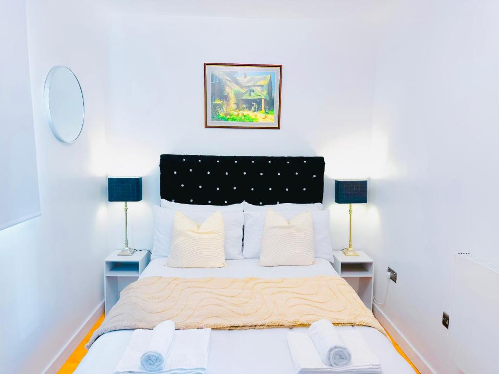 une chambre avec un grand lit avec deux lampes dans l'établissement Elegant 1 bed flat, Sleeps 4, Free parking, Pet friendly, Pudsey, Leeds, à Pudsey