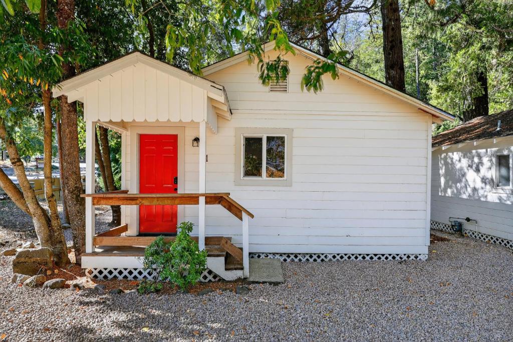 a small white house with a red door at Cozy Cabin Near Wineries, Harbin Hot Springs cabin in Cobb