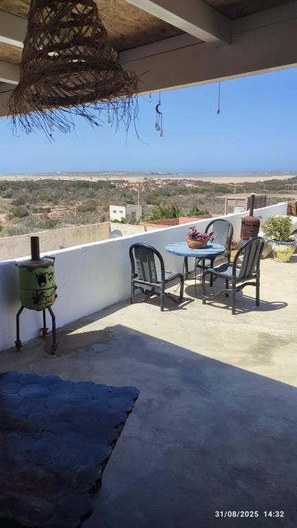 a patio with a table and chairs on a roof at Diabat hostel in Essaouira