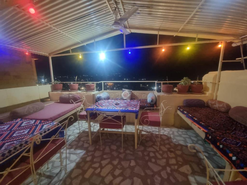 a room with a table and some beds and lights at Hotel Temple View in Jaisalmer