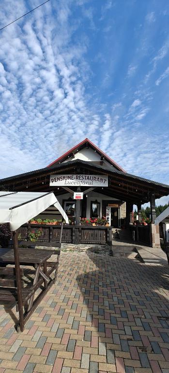 a building with a table and benches in front of it at Pensiunea Luceafărul, Pasul Mestecăniș in Valea Putnei