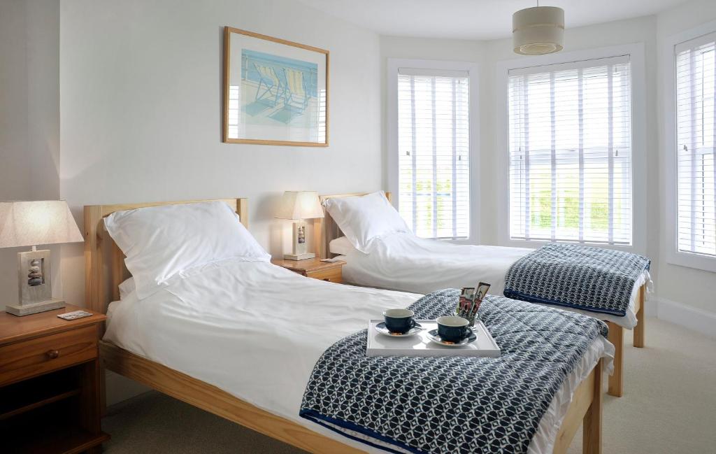 a bedroom with two beds and a table with cups on it at Surf Haven in Bude