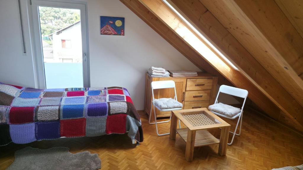 a bedroom with a bed and chairs in a attic at Privatzimmer Freimann in Munich
