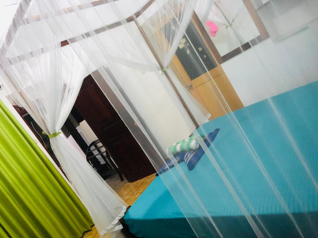 a room with a blue table and a green couch at Ancient Tree in Mirissa