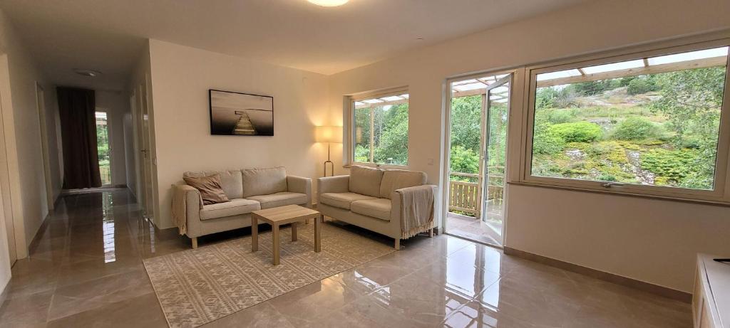 a living room with two chairs and a table and windows at Modern Full Comfort Villa in Agnesberg