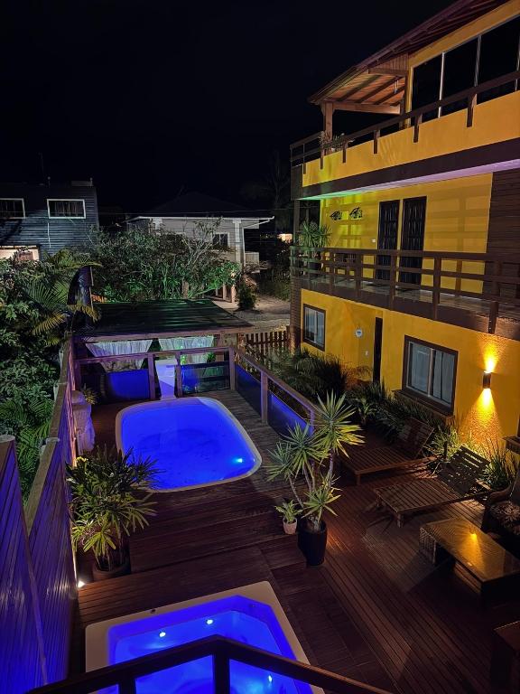 a swimming pool on the deck of a building at night at Pousada Maria Eduarda in Guarda do Embaú