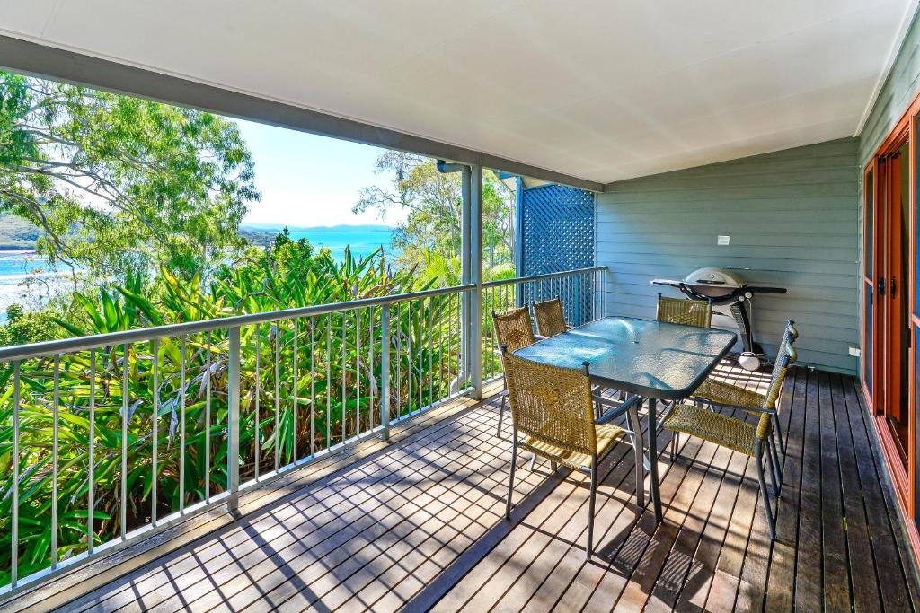 a balcony with a table and chairs on it at Heliconia Grove 9 in Hamilton Island