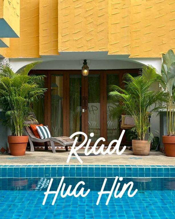 a villa with a swimming pool in front of a house at Riad Hua Hin in Hua Hin