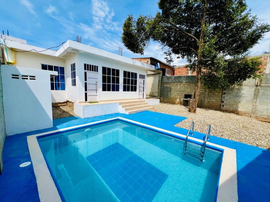 a swimming pool in front of a house at Apto con piscina a 7 min caminando de playa Bello Horizonte in Santa Marta