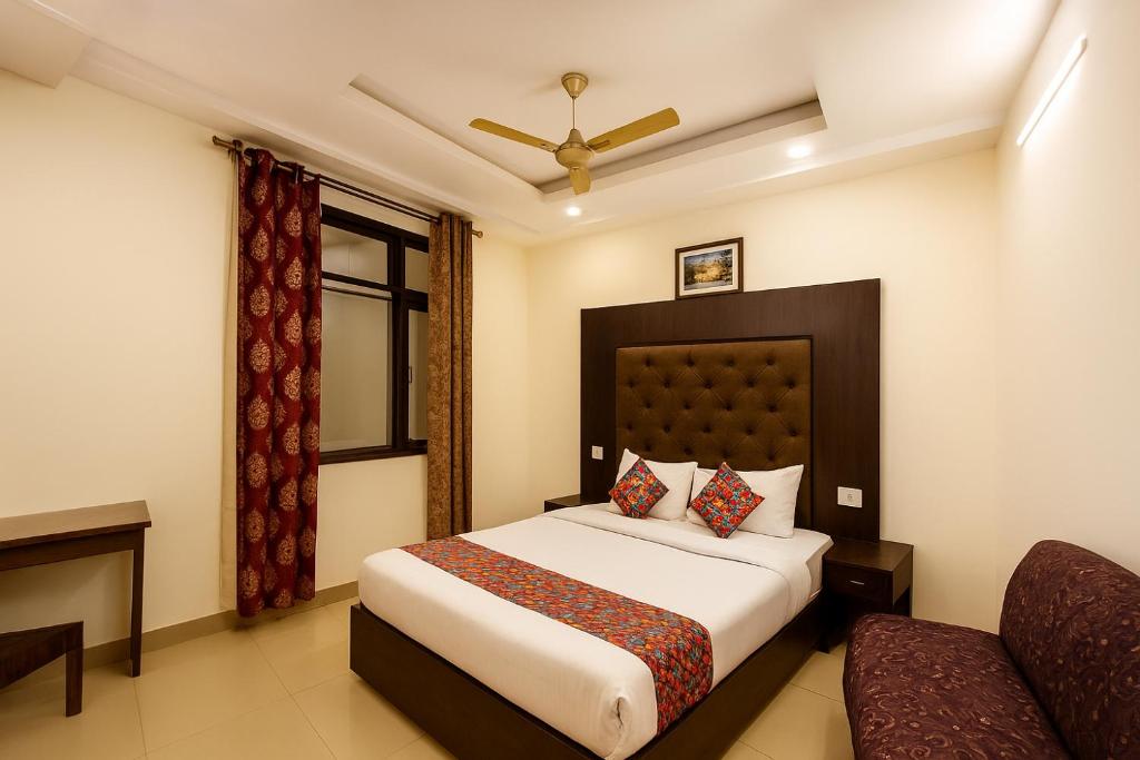 a hotel room with a bed and a couch at Hotel Vishesh Continental Karol Bagh in New Delhi