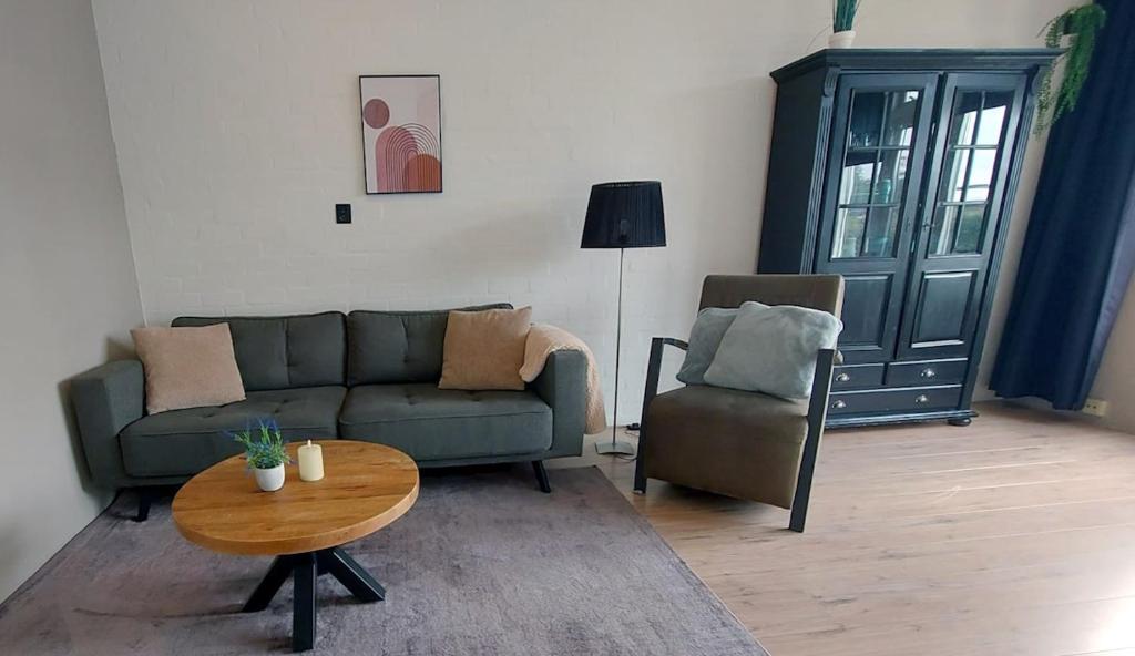 a living room with a couch and a table and a chair at Plattedijk - vakantiehuis 25-26 in Lemmer