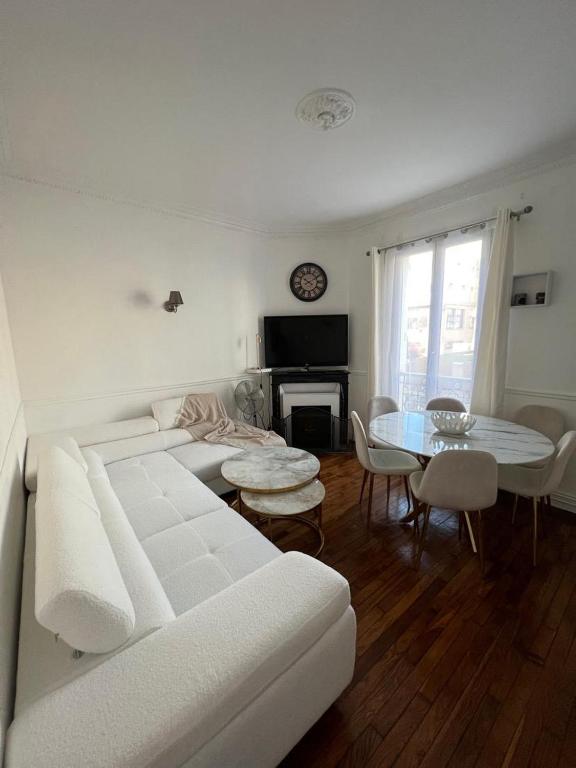 a living room with a white couch and a table at Appartement in Montreuil