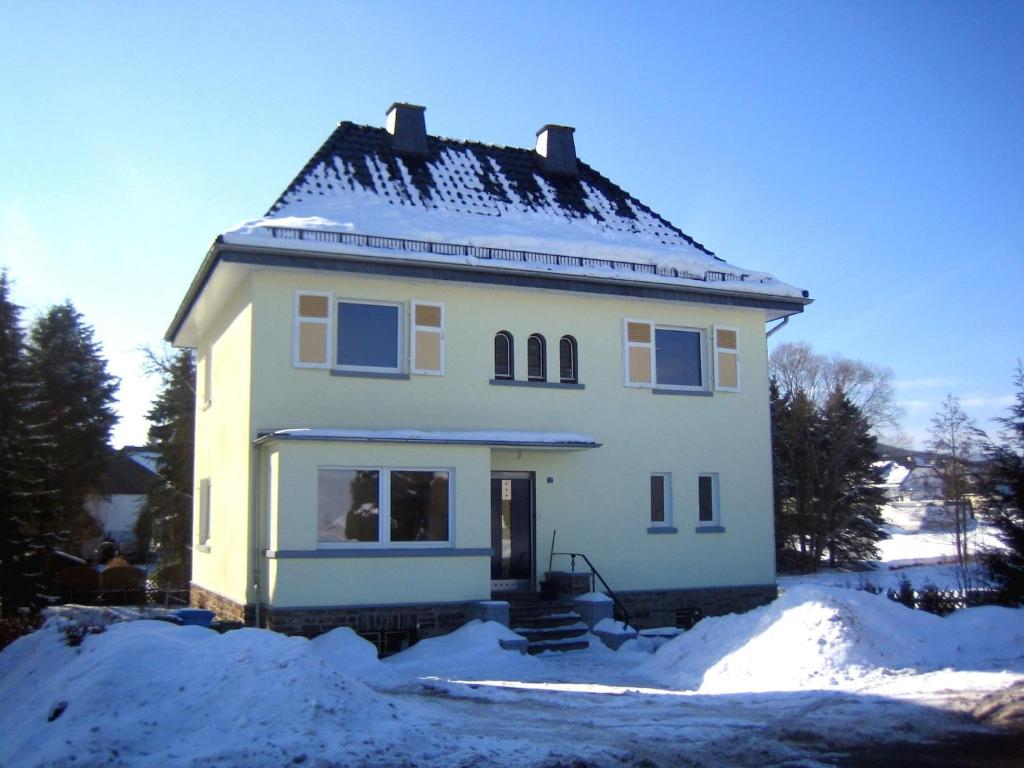 Una casa blanca con nieve encima. en Spacious Villa near Center, en Medebach