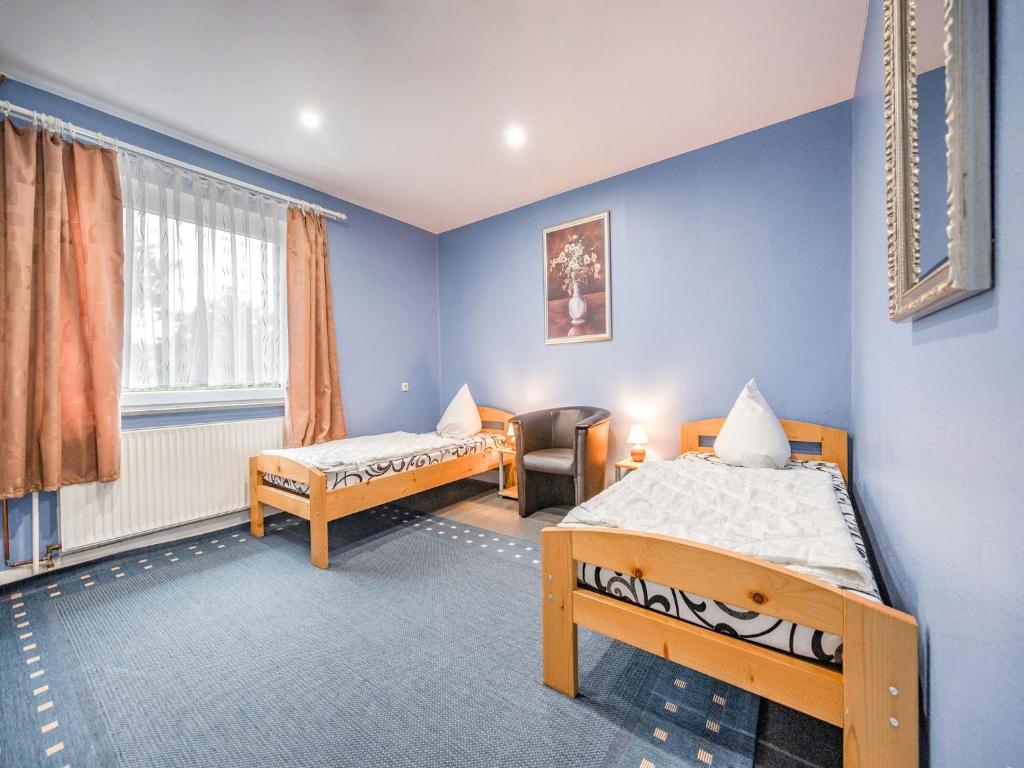 a room with two beds and a chair in it at Spacious Villa near Center in Medebach