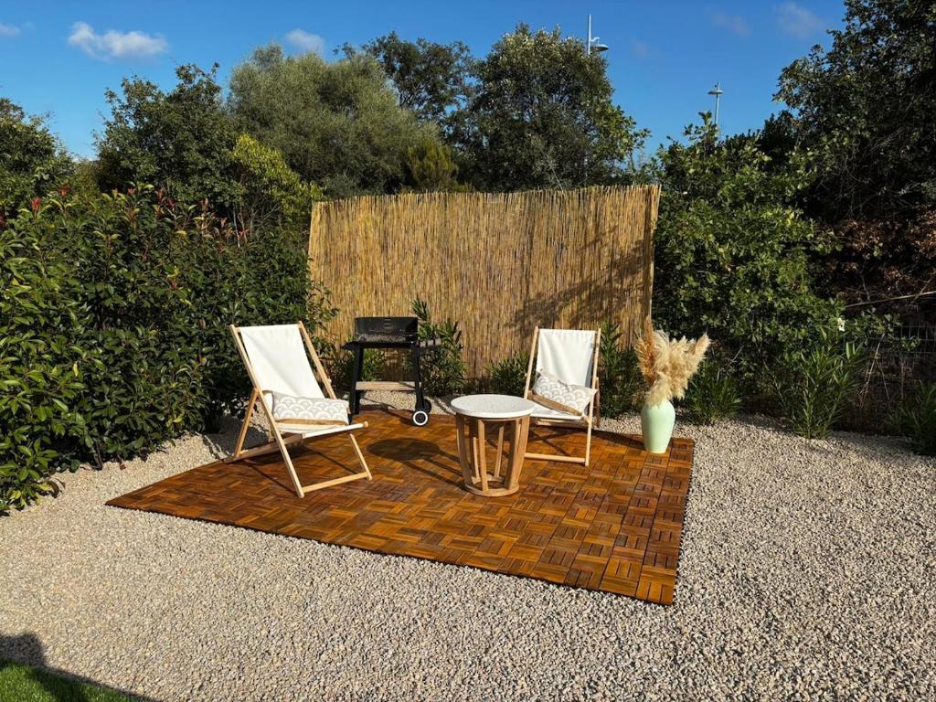 un patio con 2 sillas, una mesa y una parrilla en Maison Dolce Vita, en Ghisonaccia