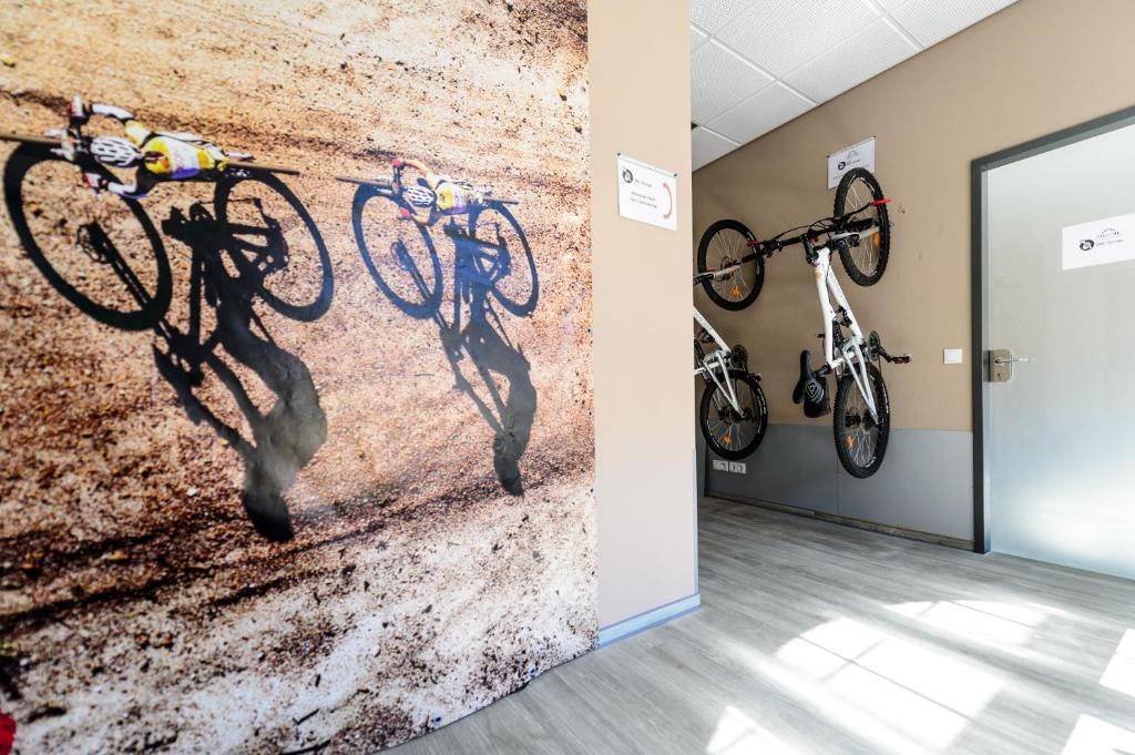 een muurschildering van fietsen aan een muur bij Trail-Inn Natur & Sporthotel in Berdorf