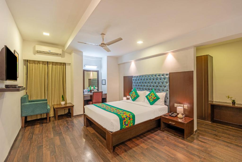 a bedroom with a bed and a desk and a chair at Treebo Comfy Business in Bengaluru
