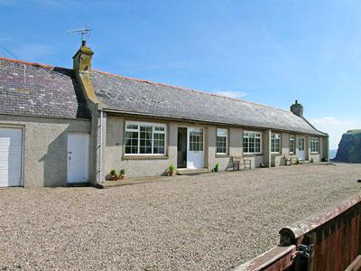 una casa con un vialetto di ghiaia davanti di Mill Shore Cottage - 26817 a Pennan