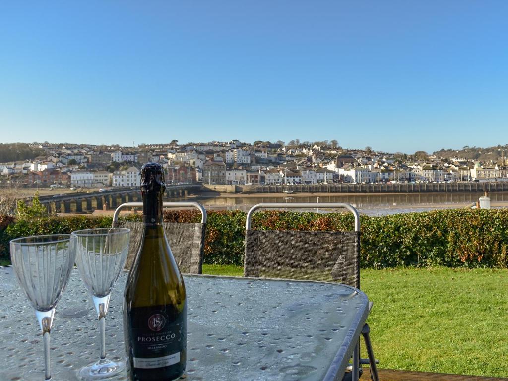 a bottle of wine sitting on a table with two wine glasses at The Orchard in Bideford