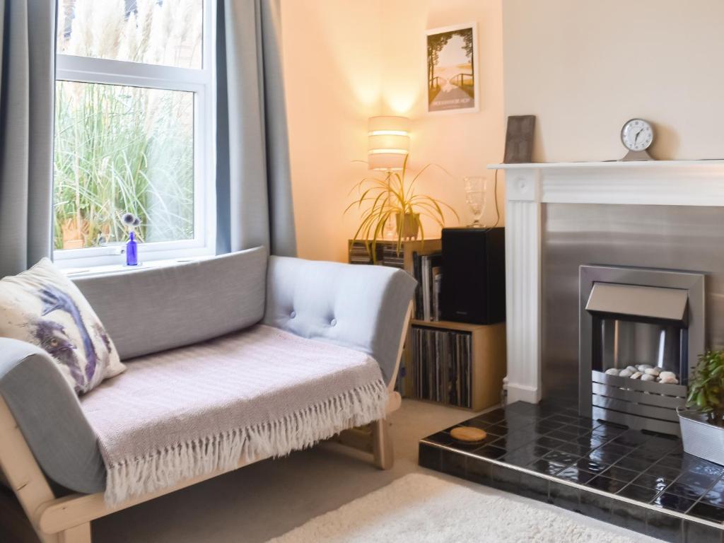 a living room with a couch and a fireplace at Ratcliffe Cottage in Ipswich