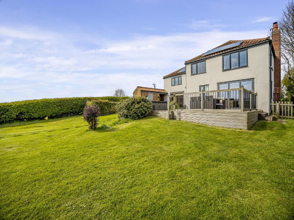 une maison avec une grande pelouse devant dans l'établissement The Cottage, à Salmonby