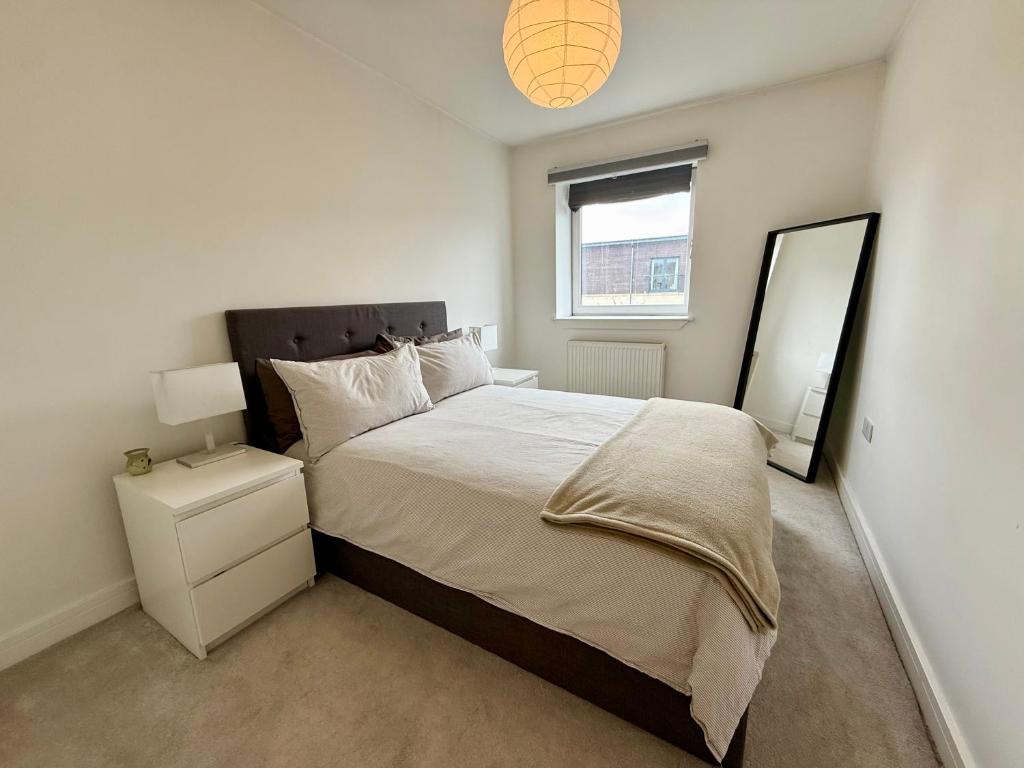 a bedroom with a large bed and a mirror at Cosy apartment near Edinburgh city centre in Edinburgh