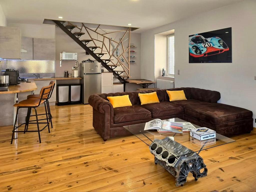 Una sala de estar con un sofá marrón y una mesa. en Le Mans 70 Duplex, 