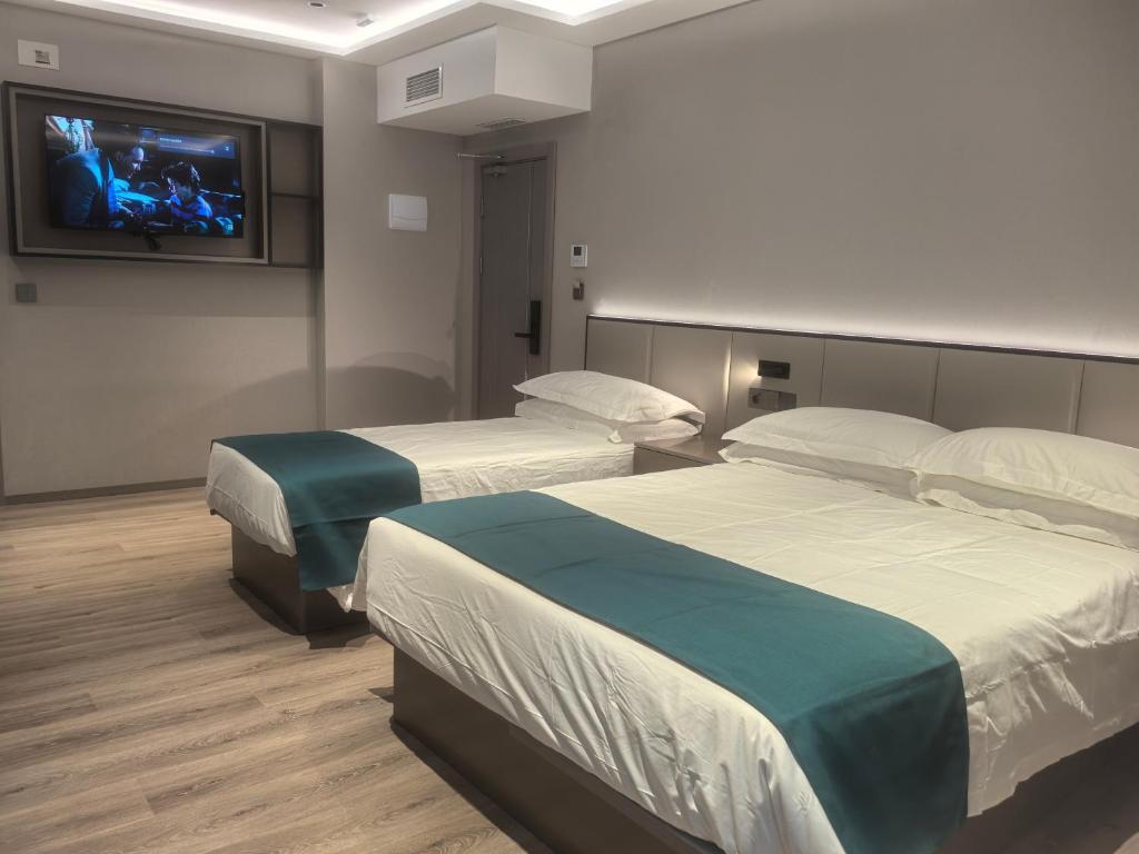 two beds in a room with a tv on the wall at Hotel Calagurris in Calahorra