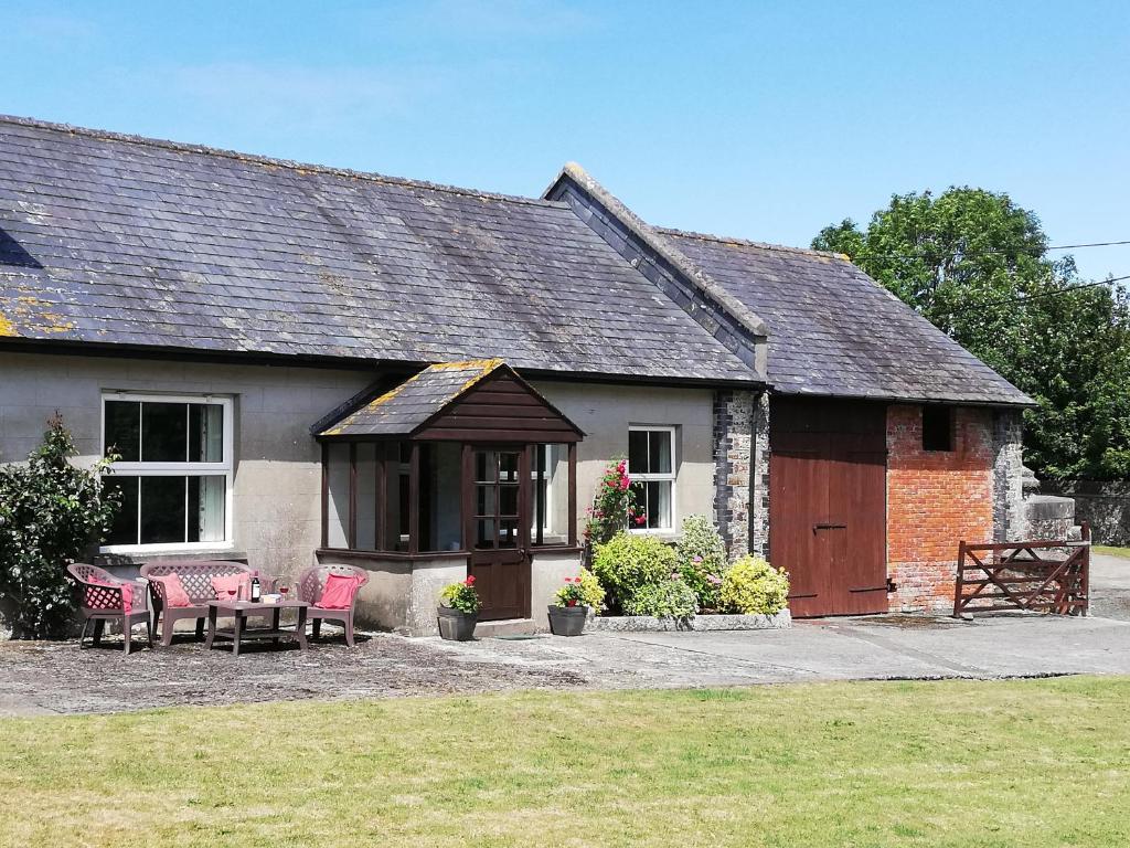 a house with a table and chairs in front of it at Penfound Country Cottage in Poundstock