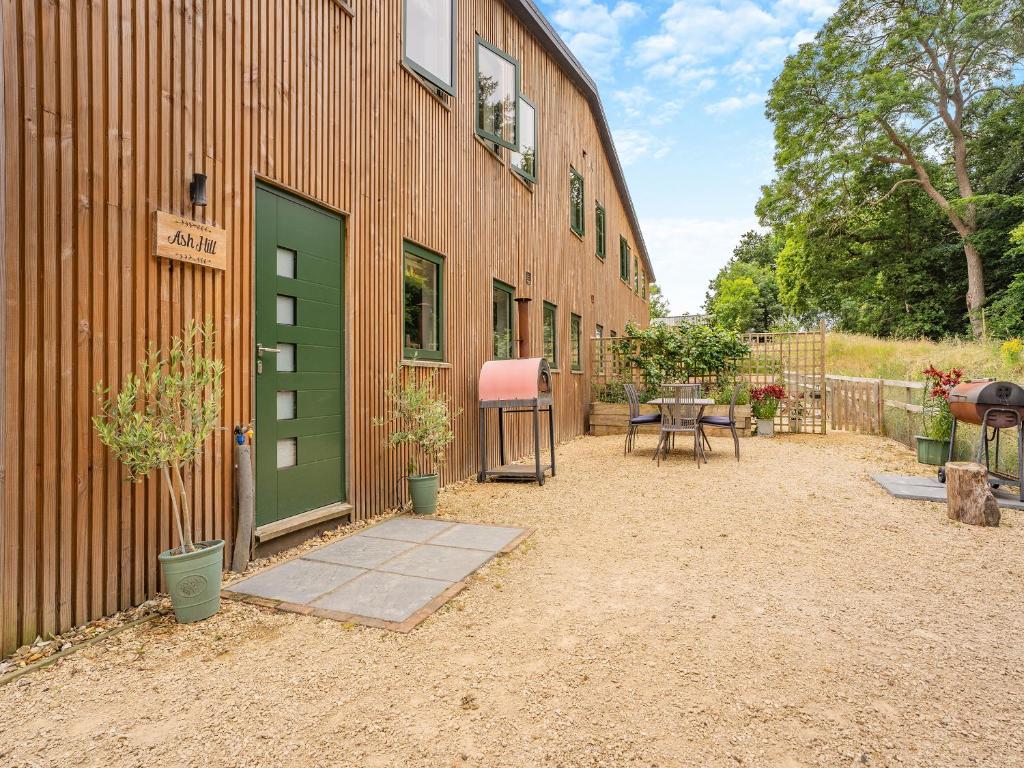 a building with a green door and a table at Ash Hill - Uk36199 in Fordingbridge