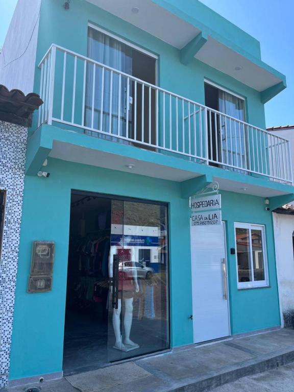 a blue building with a woman in a store window at Hospedaria Casa da Lia in Mucugê