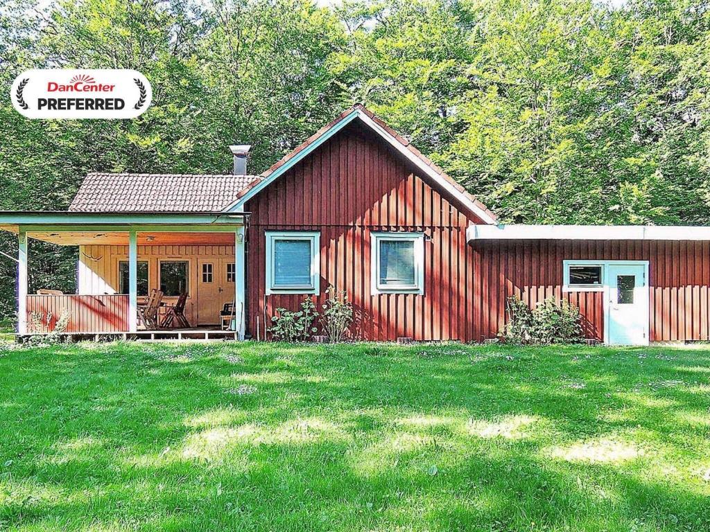 a small red house with a porch on a yard at 6 person holiday home in HÄSTVEDA-By Traum in Hästveda