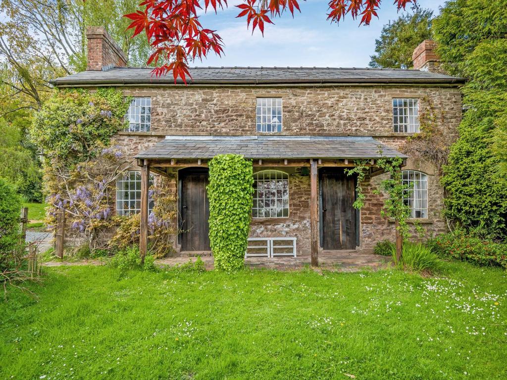 an old stone house with ivy on the front of it at Upper House - Uk48805 in Hereford