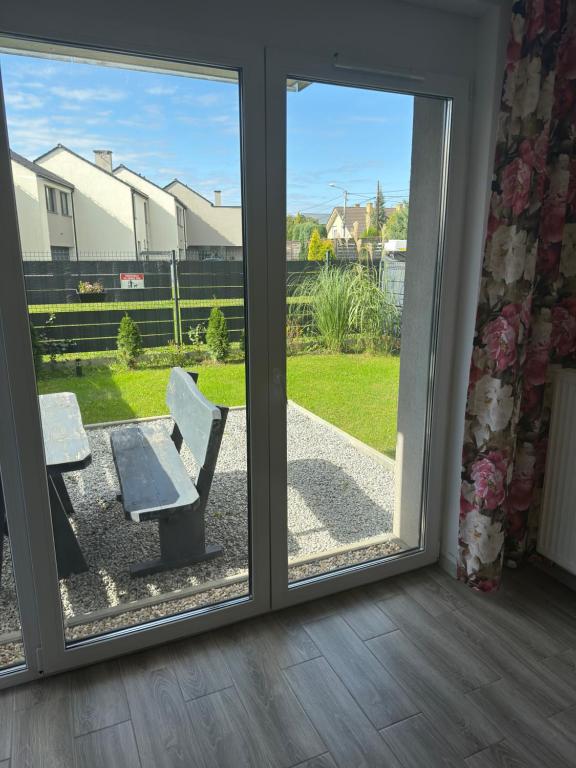a sliding glass door with a bench on a patio at 1 Tyskie Apartamenty z prywatnym ogródkiem in Tychy