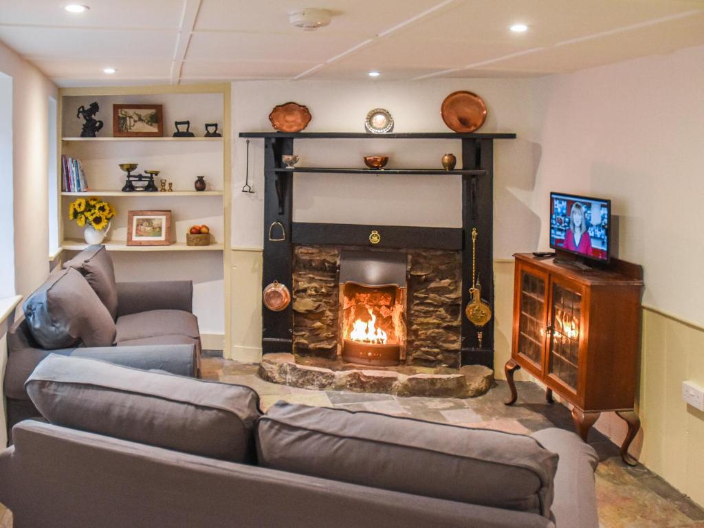 ein Wohnzimmer mit Kamin und Couch in der Unterkunft Riverside Cottage in Lynton
