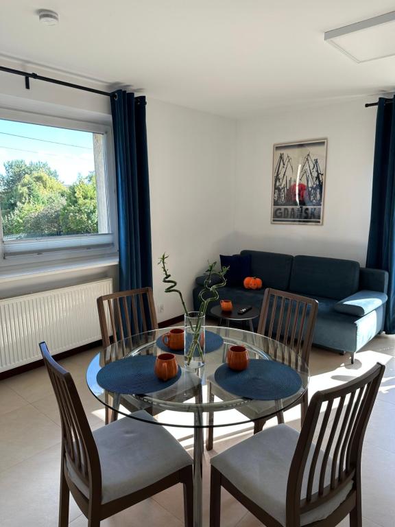 BorkowoにあるCozy Bay Apartment - 15 minutes drive from the Old Townのテーブルと椅子とソファのあるリビングルーム