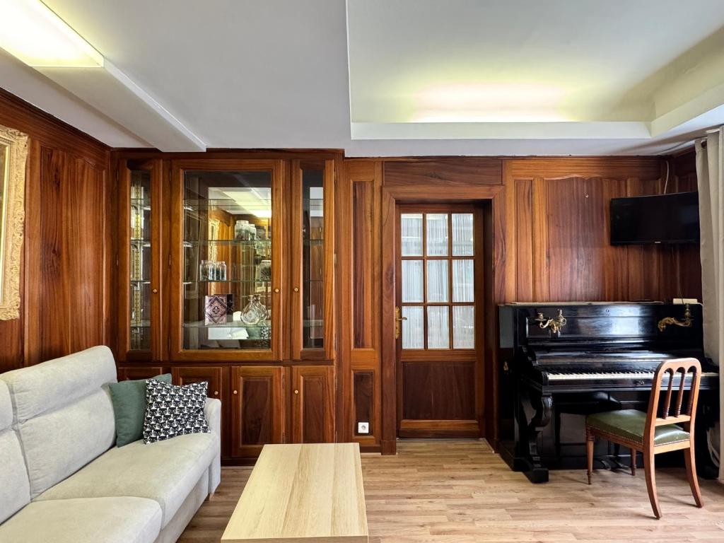 un salon avec un canapé et un piano dans l'établissement Quartier piéton. T3 65m2. 2 chambres. 5 personnes., à Cauterets