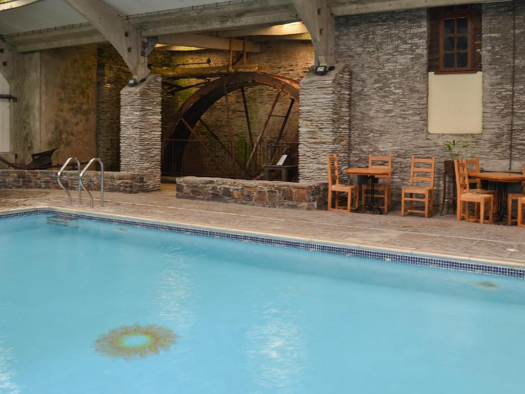 a swimming pool in a building with a table and chairs at Granary - Ukc3373 in West Down