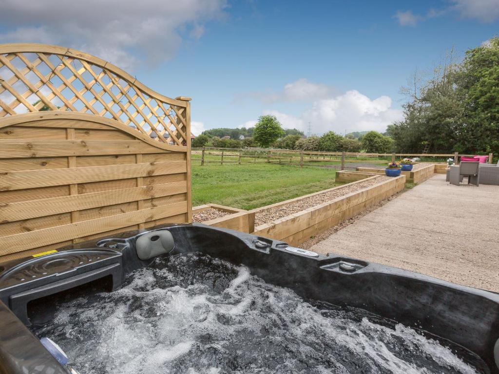 a hot tub filled with water in a garden at Sherwood Forest Lodge 1 in Clipstone