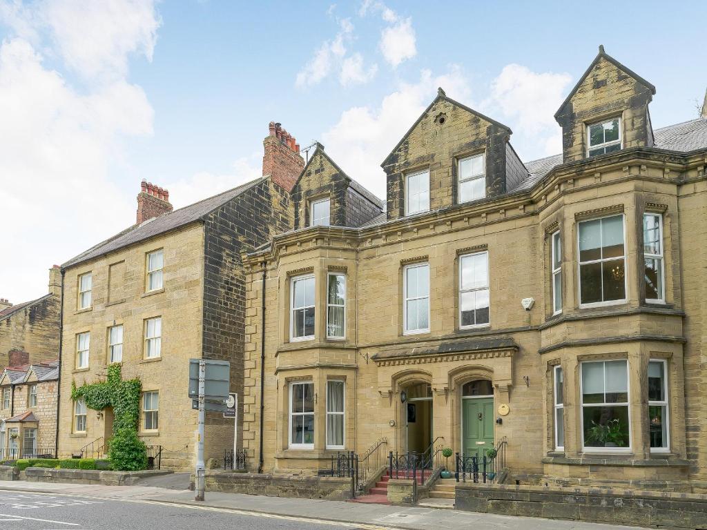 un gran edificio de ladrillo con una puerta verde en The Physicians House, en Alnwick
