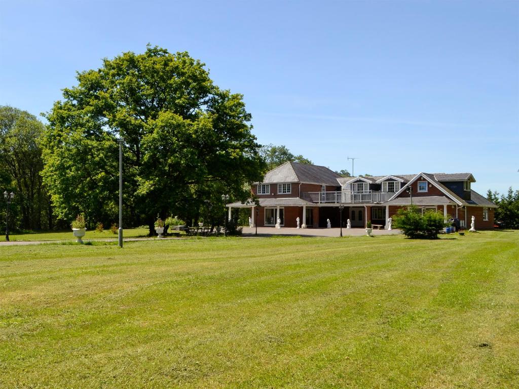 ein großes Haus mit einer großen Wiese davor in der Unterkunft Vijay Gardens in Glanamman
