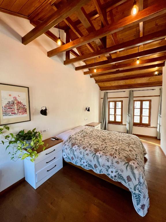 a bedroom with a bed and a wooden ceiling at Our Townhouse in Gjirokastër