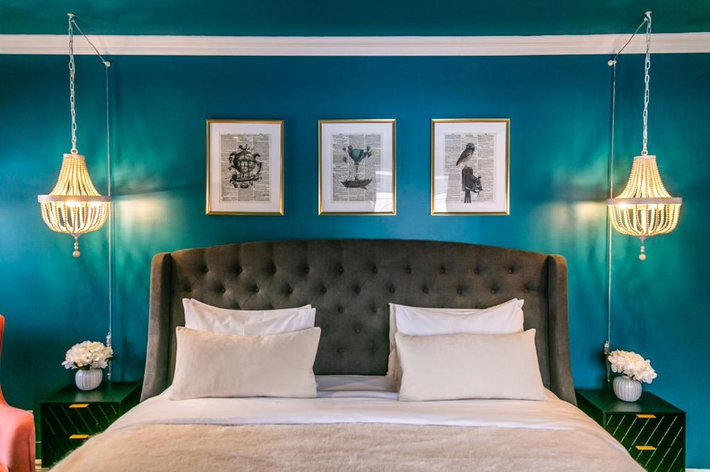 BécancourにあるManoir Becancourt Hotelの青い壁のベッドルーム1室、ベッド1台(白い枕付)