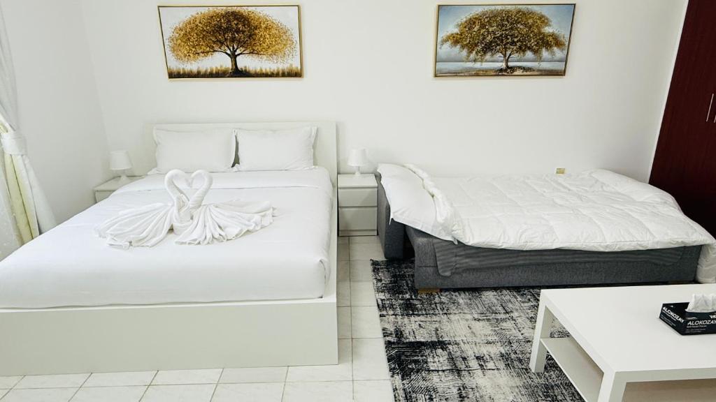 a hotel room with two beds and a table at Z01 Furnished Studio Garden view International city in Dubai