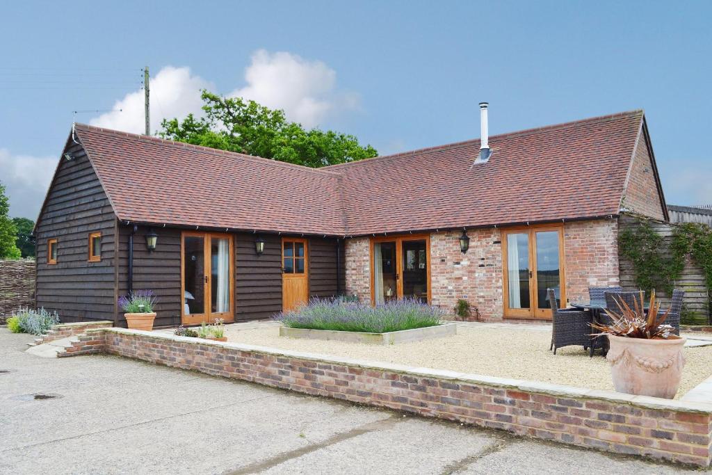 a home with a brick and brown roof at The Peacock Barn in Burwash