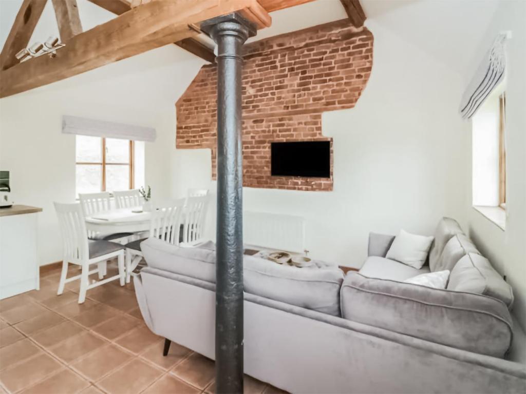 un soggiorno con un divano e un muro di mattoni di Uk46555 - Ragleth a Church Stretton