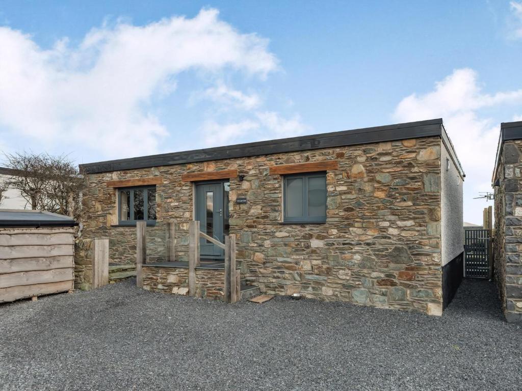 a stone house with a black roof at Ty Cwtch in Holyhead